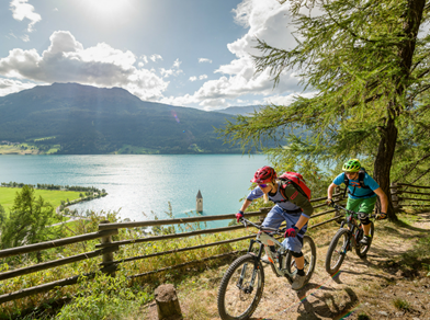Two people on a mountain bike tour around Lake Resia